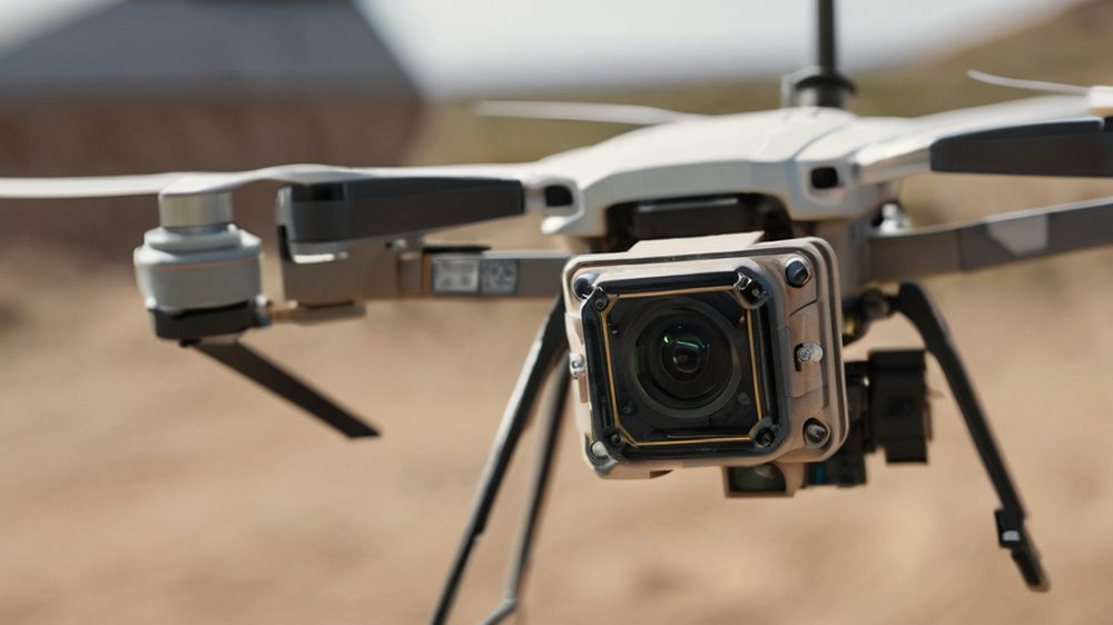 Ukraine upgrades cheap drones with autonomous visual tracking to defeat jamming A detailed macro shot of a small electronic sensor unit mounted on a drone, focusing on the lens and circuitry, set agai